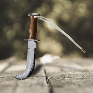 Corvo comando cromado con empuñadura de madera natural y cordón trenzado claro.